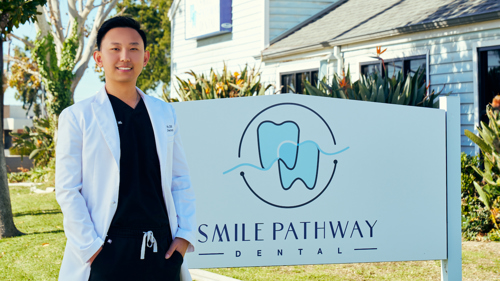 Photo of Dr. Wu in front of practice sign
